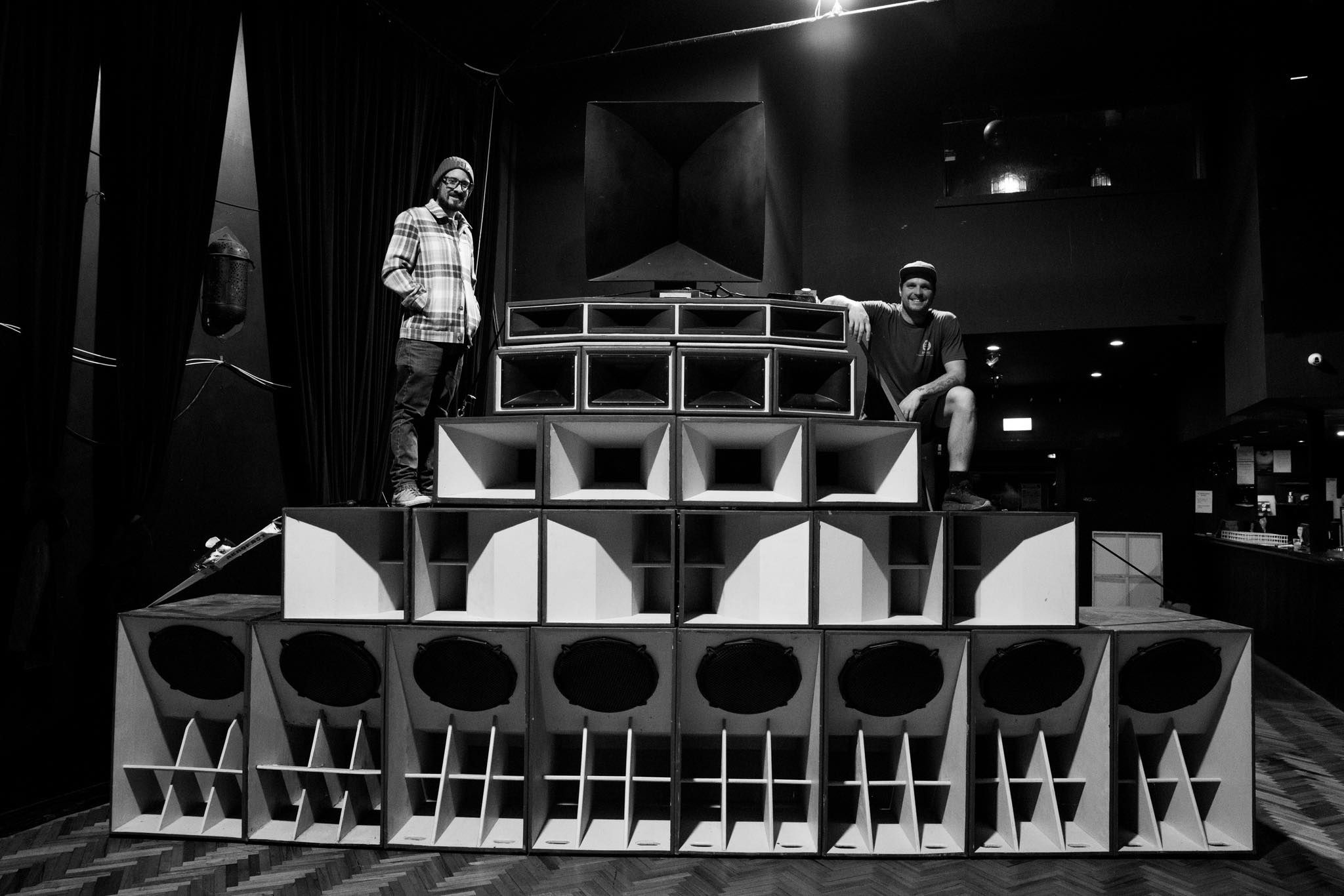 two people standing over a massive soundsystem